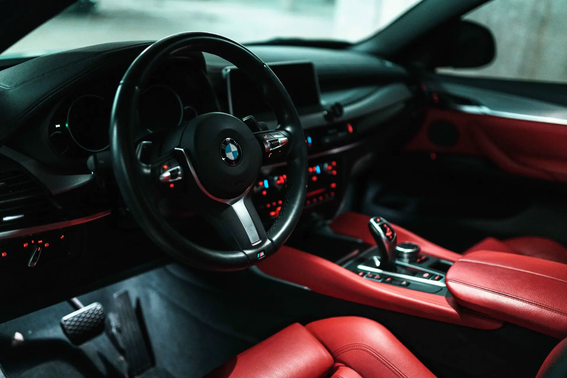 Red leather car interior with steering wheel, gauges and center console after an interior detail